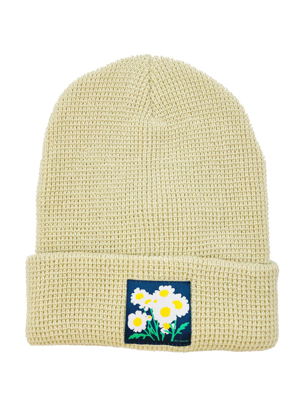 CULK | Feverfew Daisy Beanie, Cream | Flat lay of cuffed waffle knit beanie with patch on front of cuff