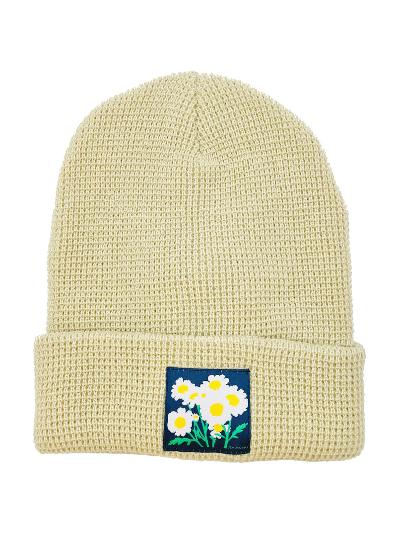 CULK | Feverfew Daisy Beanie, Cream | Flat lay of cuffed waffle knit beanie with patch on front of cuff